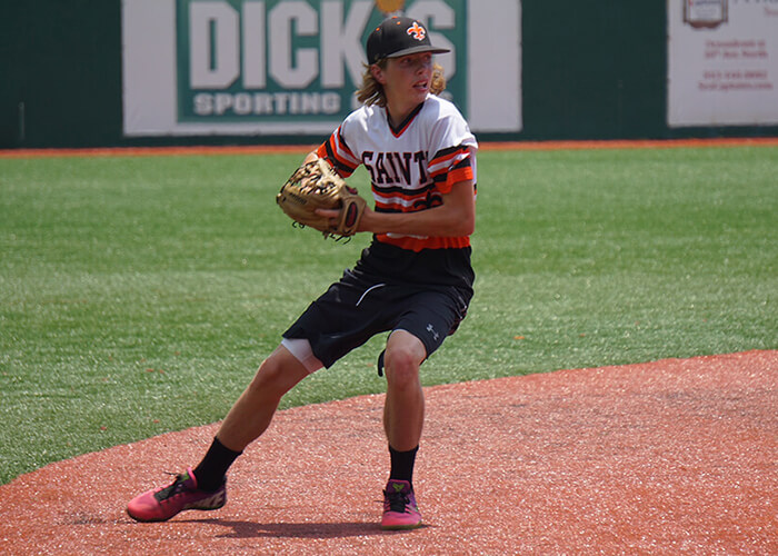 Young Kevin White winding up a throw on a baseball field